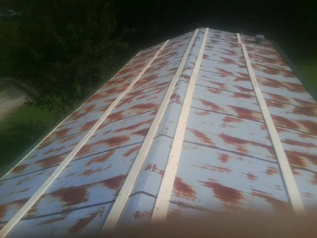 Rusted metal roof panels with new wood purlins before replacement — Storm Damage Roof Repair in Hamlet by Roofing Brothers