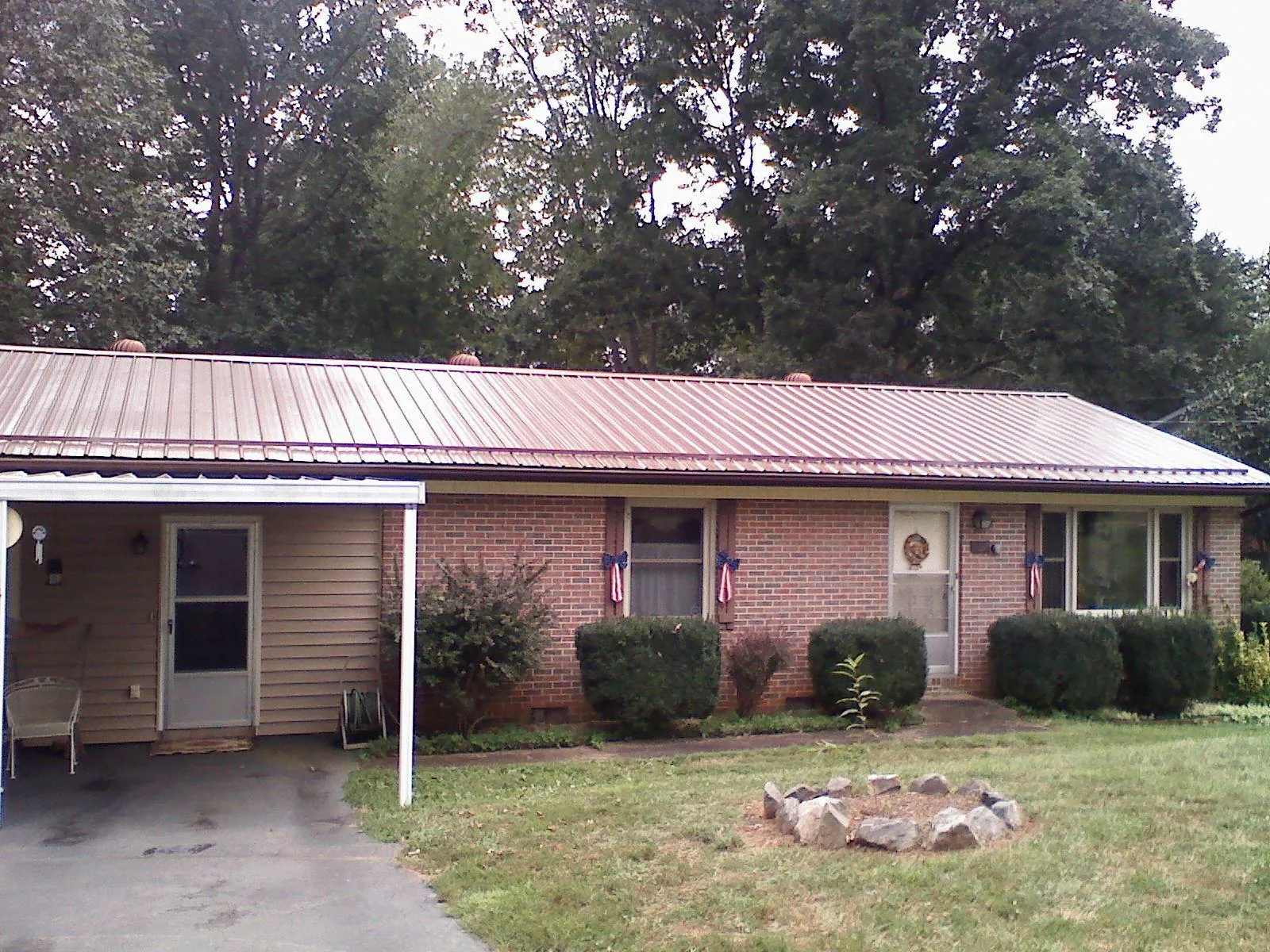Bronze metal roof and carport on a brick ranch home — Roof Repair work by our crew in Hamlet